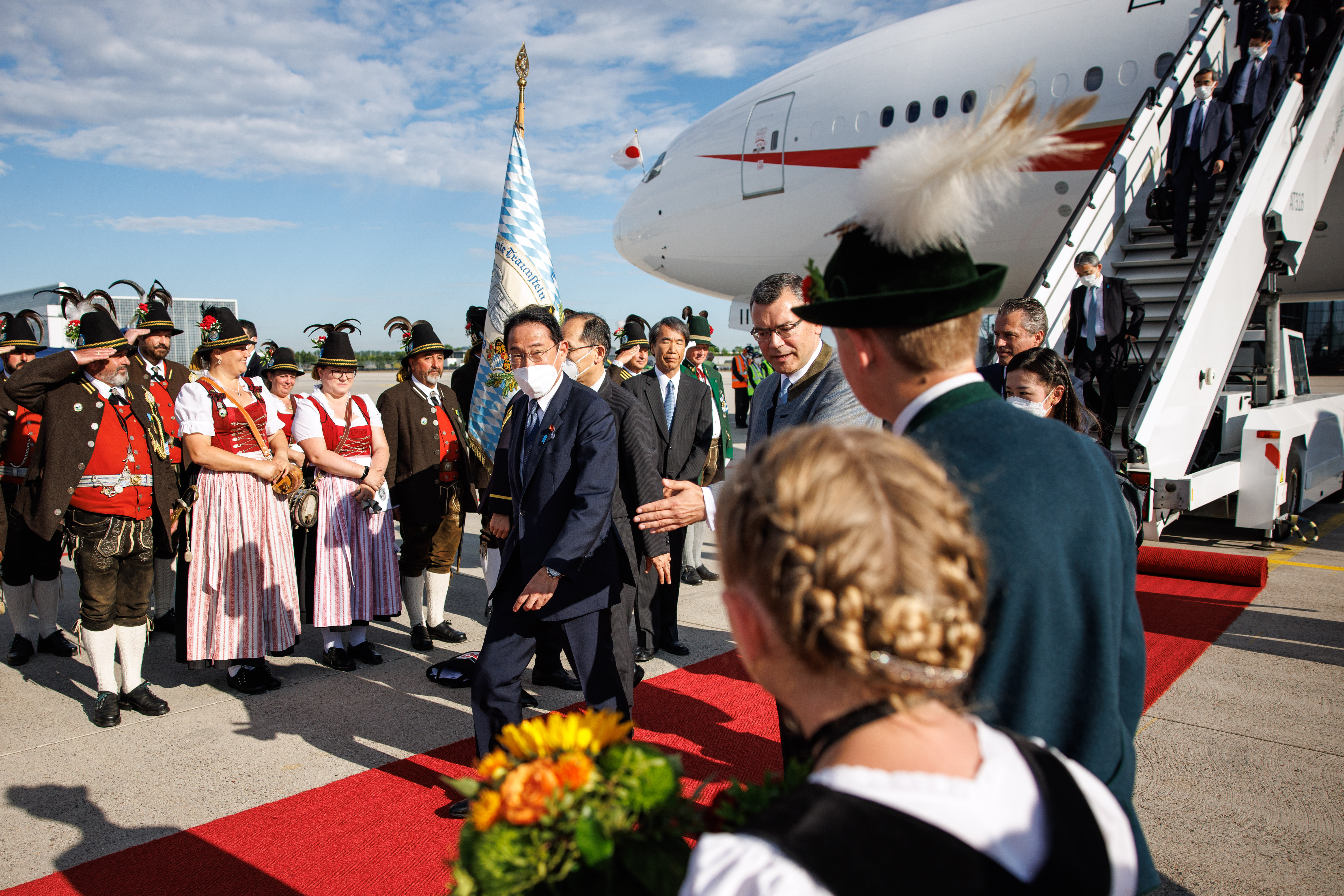 Ankunft von Fumio Kishida (Ministerpräsident Japan) auf dem Flughafen München, Begrüßung durch Florian Herrmann, Leiter der Bayerischen Staatskanzlei und Angehörige eines Trachtenvereins.