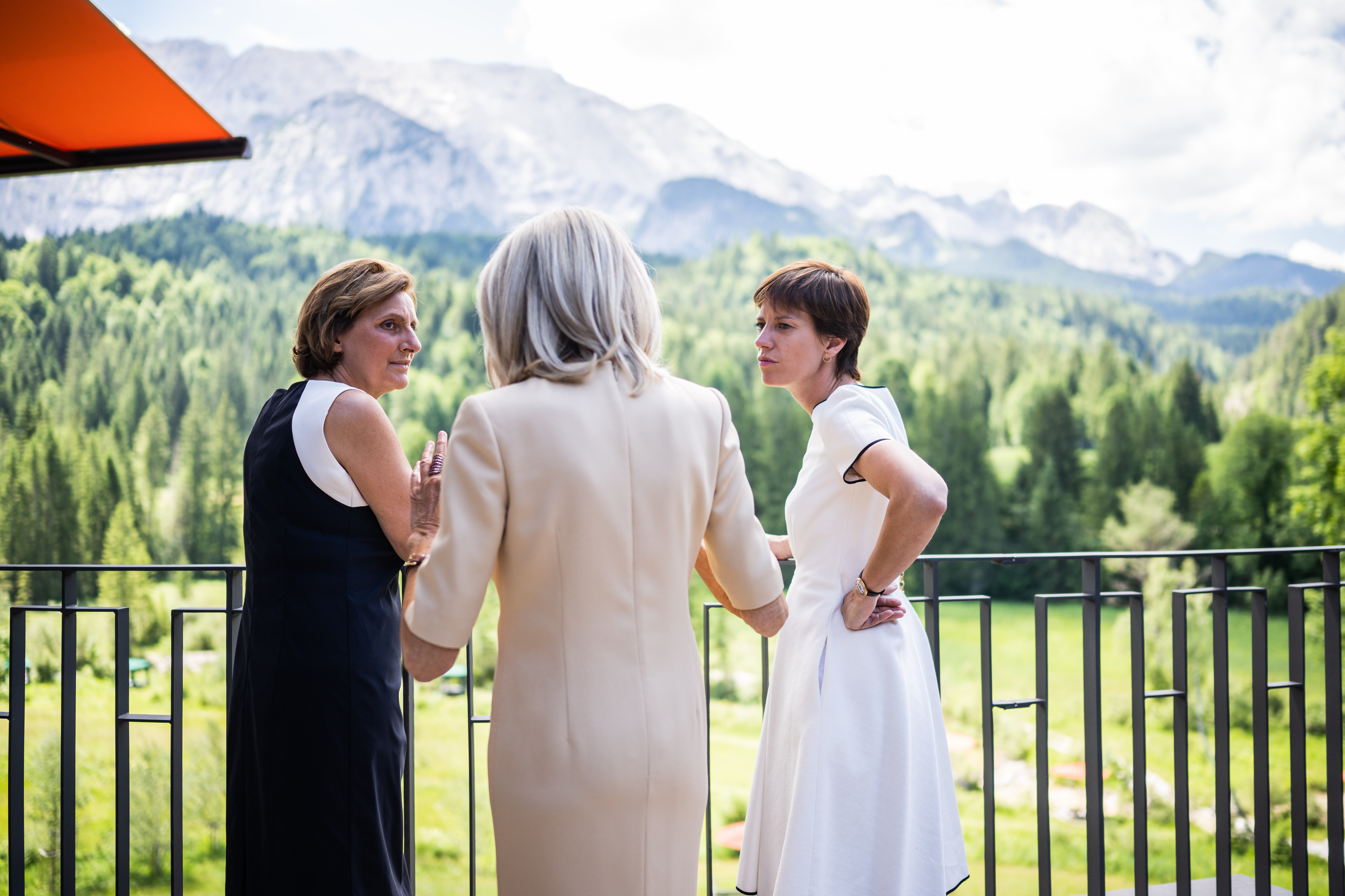 Britta Ernst (l) zeigt Brigitte Macron (m) und Amélie Derbaudrenghien den Ausblick auf das Wettersteingebirge vor dem gemeinsamen Mittagessen auf Schloss Elmau.