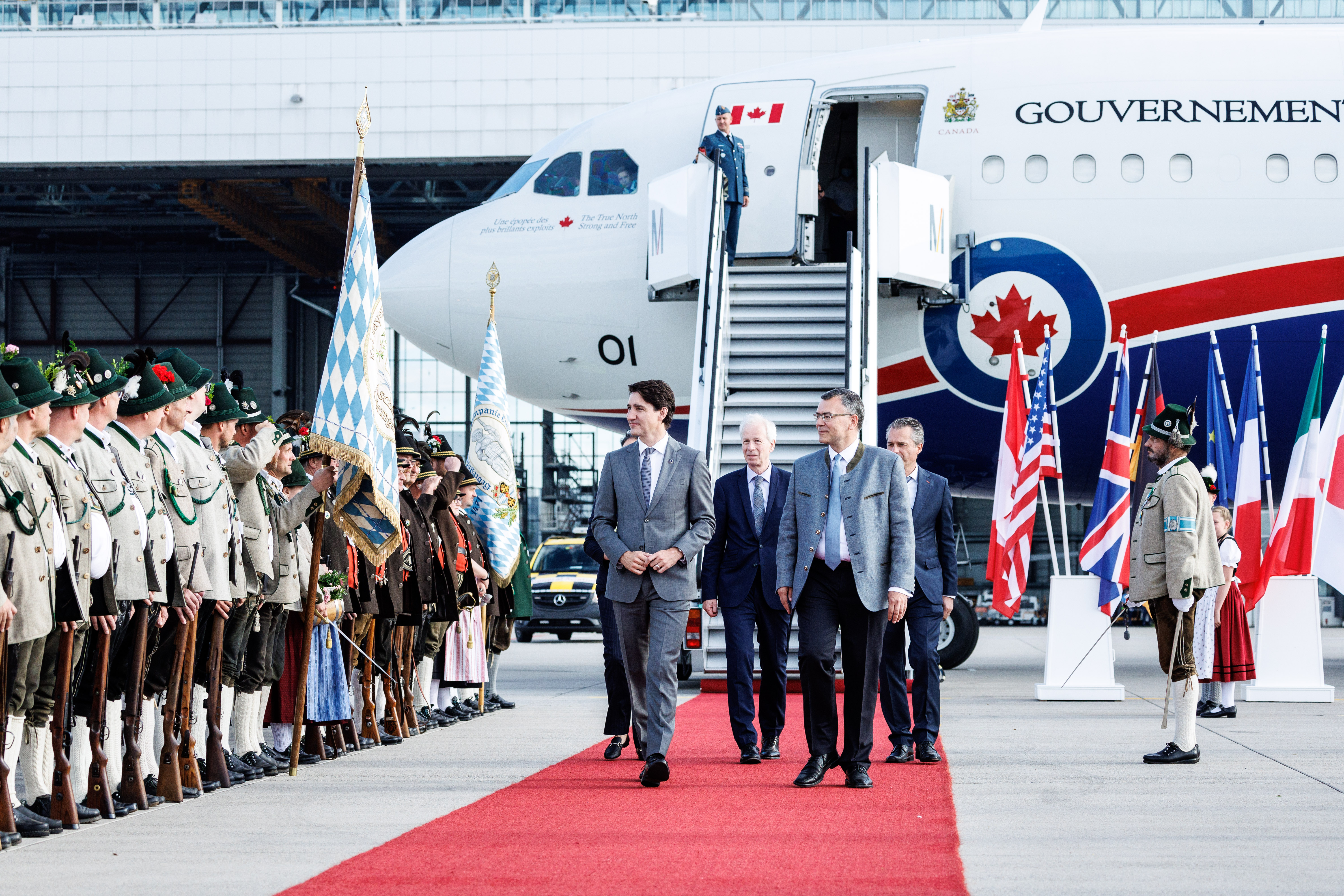 Justin Trudeau (Prime Minister of Canada) is welcomed at Munich Airport by members of a group wearing traditional Bavarian costume.