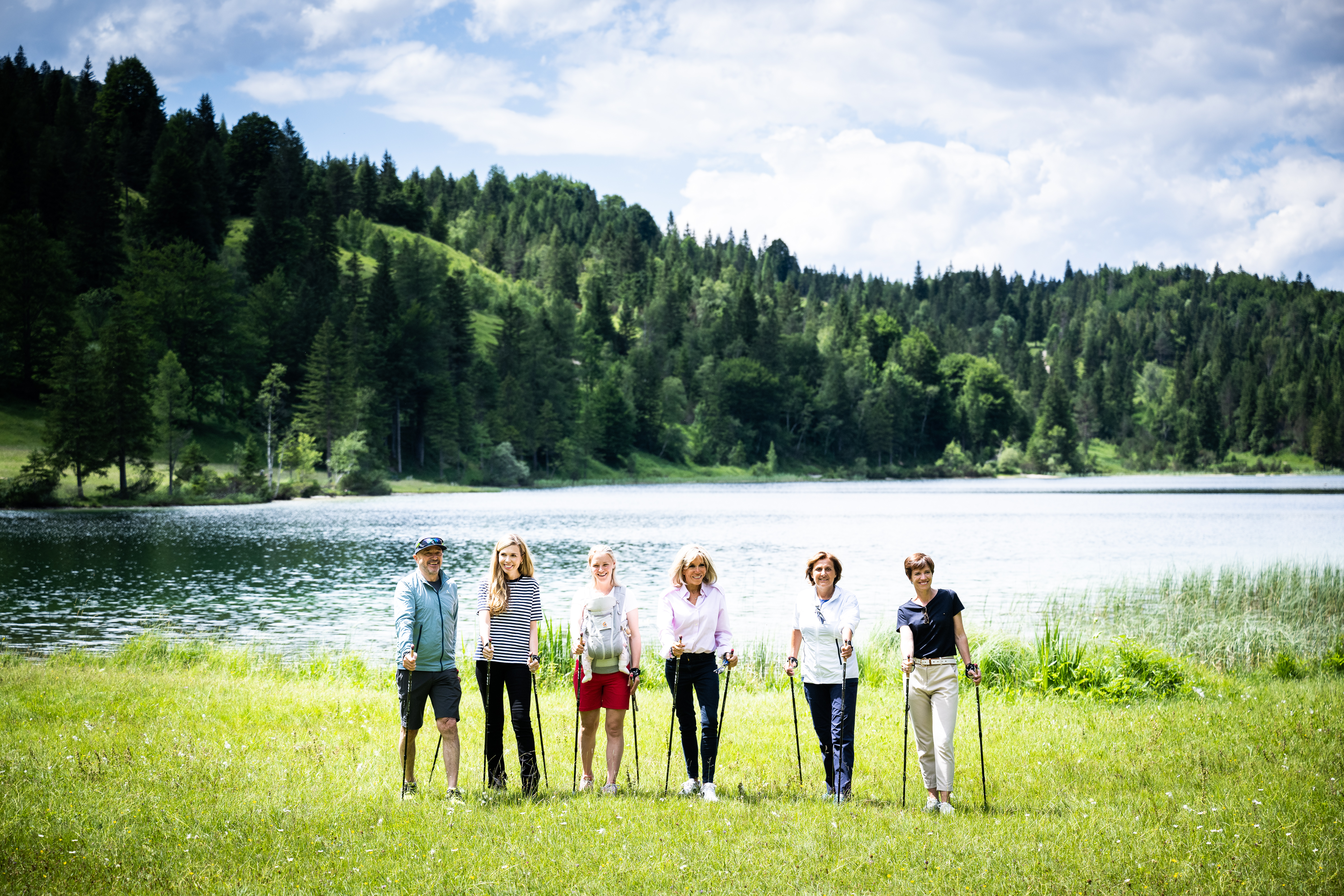 Group photo – Christian Neureuther, Carrie Johnson, Miriam Neureuther, Brigitte Macron, Britta Ernst and Amélie Derbaudrenghien pose beside the Ferchensee.