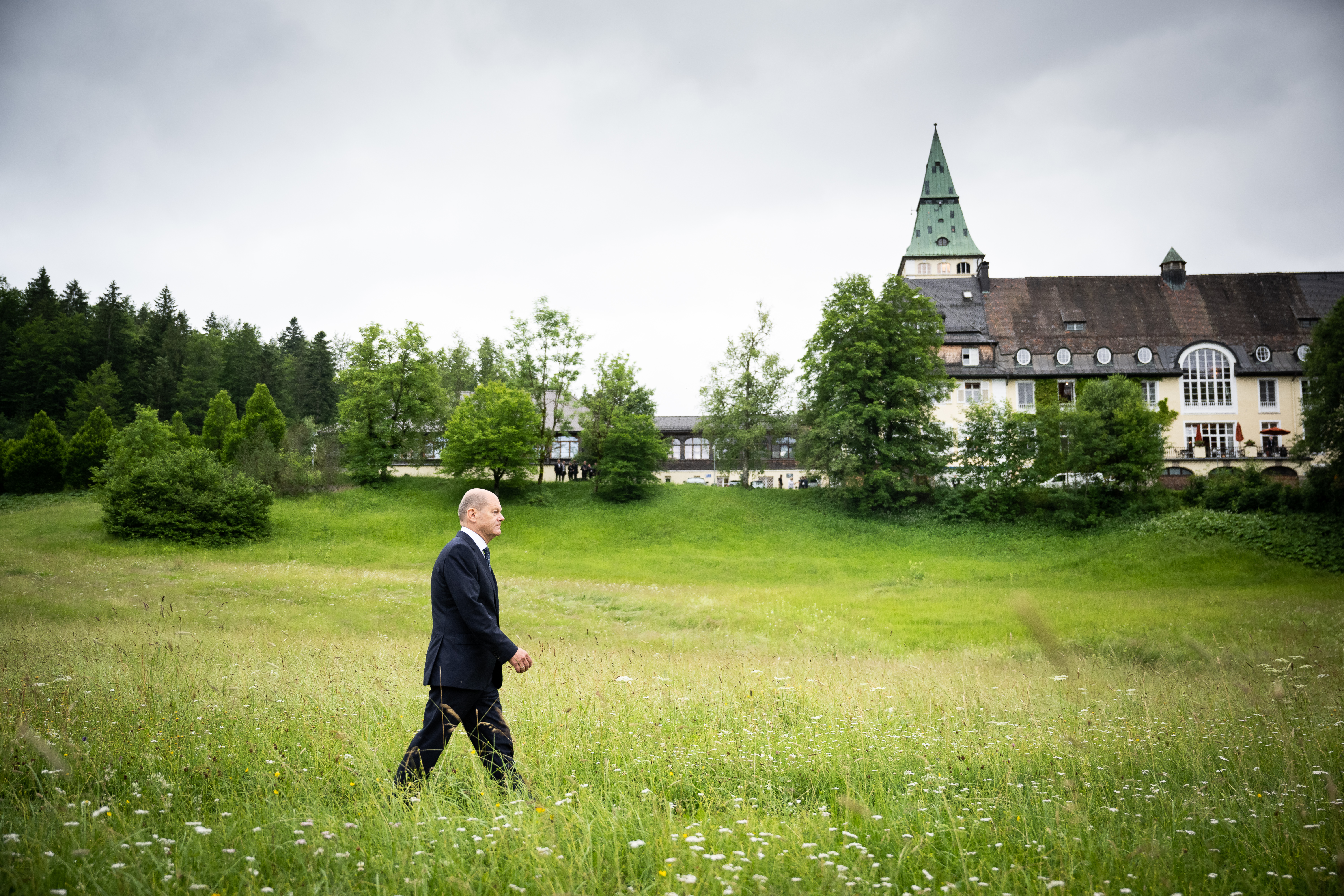 Federal Chancellor Olaf Scholz walks to the final press conference of the G7 summit. In the background we see Schloss Elmau.