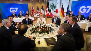 Participants of the G7 Summit sitting round a table before their evening meal