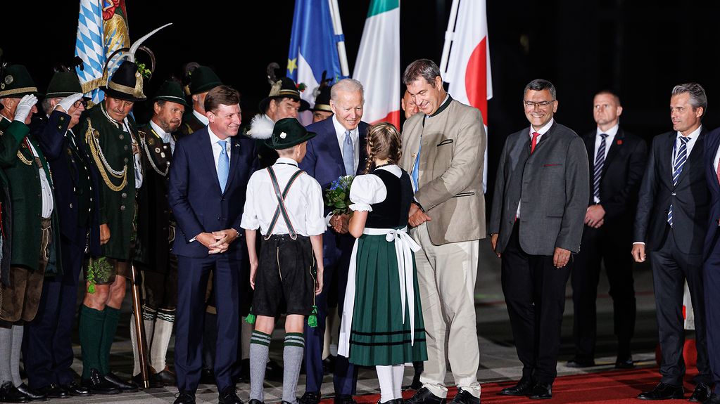 Arrival of Joe Biden (US President) at Munich Airport and welcome by Markus Söder, Minister-President of Bavaria and children wearing traditional costume.