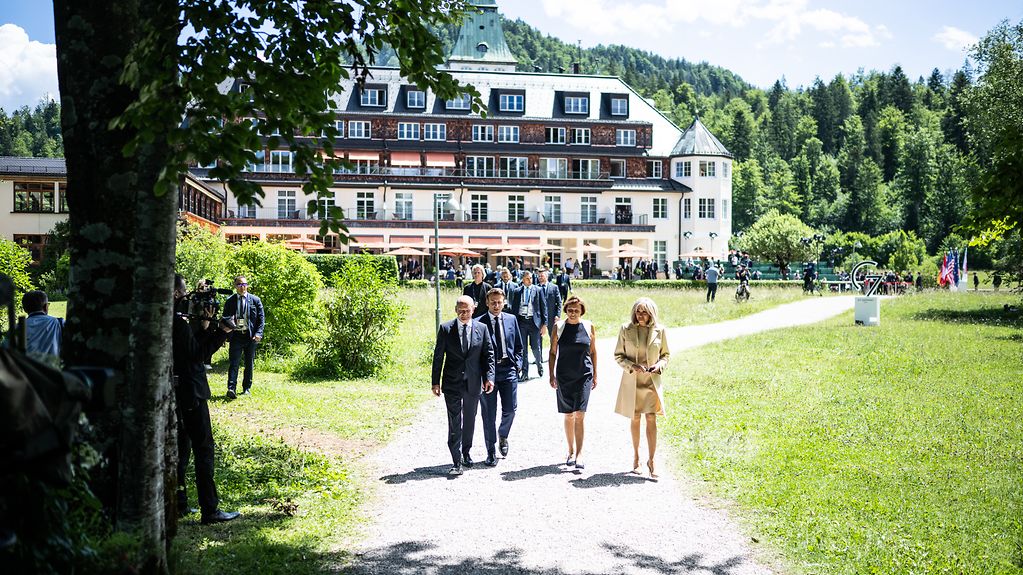 Bundeskanzler Olaf Scholz, seine Frau Britta Ernst, Emmanuel Macron (Präsident Frankreich) und dessen Frau Brigitte Macron, während der Begrüßung zum G7-Gipfel vor Schloss Elmau.