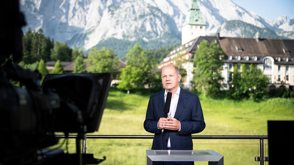Bundeskanzler Olaf Scholz während einer TV-Schalte mit dem ZDF-Morgenmagazin. Im Hintergrund Schloss Elmau.