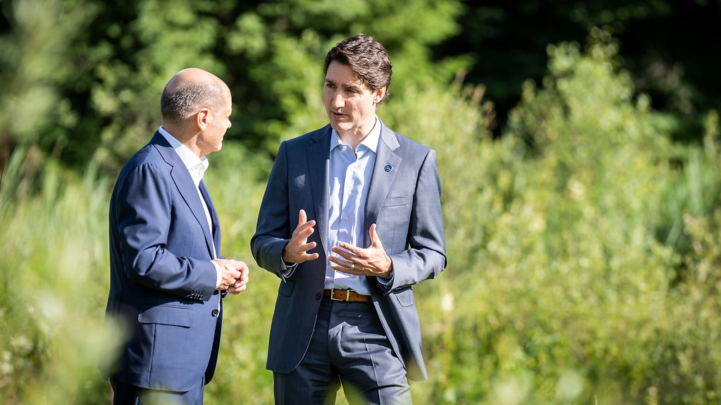 Bilaterales Gespräch zwischen Bundeskanzler Olaf Scholz und Kanadas Premierminister Justin Trudeau während eines Spaziergangs.