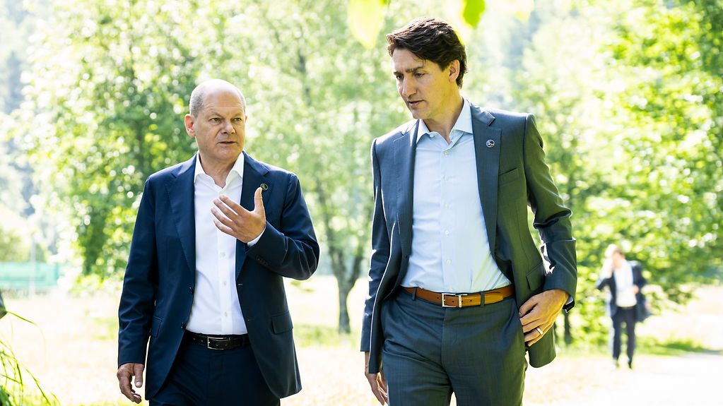 Bilaterales Gespräch zwischen Bundeskanzler Olaf Scholz und Kanadas Premierminister Justin Trudeau während eines Spaziergangs.