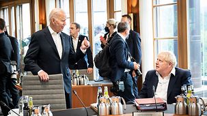Joe Biden spricht am Sitzungstisch mit Boris Johnson.