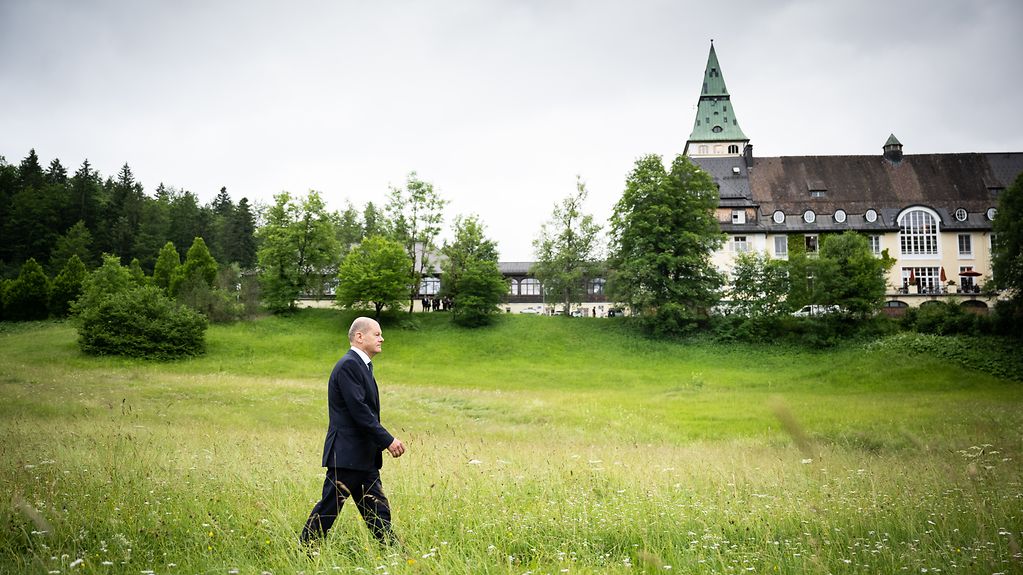 Bundeskanzler Olaf Scholz beim Gang zur Pressekonferenz zum Abschluss des G7-Gipfels. Schloss Elmau im Hintergrund.