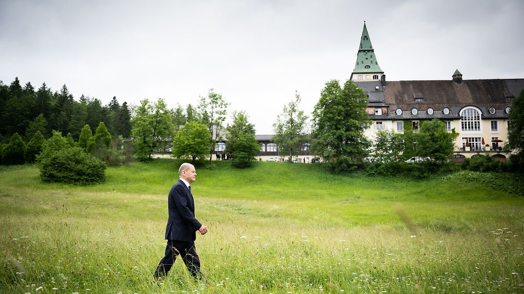 Federal Chancellor Olaf Scholz walks to the final press conference of the G7 summit. In the background we see Schloss Elmau.