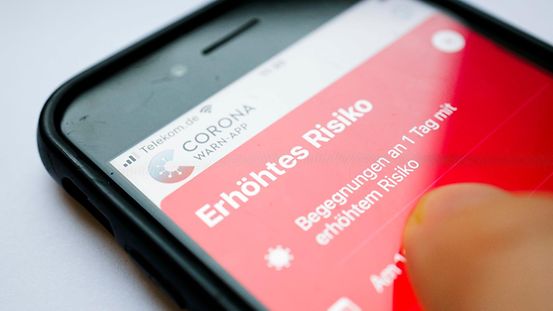 The Corona-Warn-App shows the words “elevated risk” on a smartphone. At-risk contacts