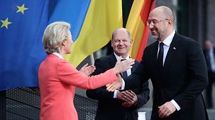 Bundeskanzler Olaf Scholz und Ursula von der Leyen, Präsidentin der Europäischen Kommission, begrüßen Denys Schmyhal, Ministerpräsident der Ukraine, zur Internationalen Expertenkonferenz zum Wiederaufbau der Ukraine