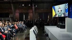 Wolodymyr Selensky, ukrainischer Präsident, auf einem Monitor bei der Internationalen Expertenkonferenz zum Wiederaufbau der Ukraine