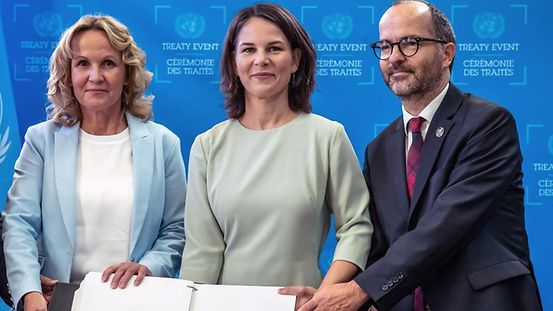 Außenministerin Annalena Baerbock, steht zwischen Bundesumweltministerin Steffi Lemke (links), sowie Sebastian Unger (rechts) Meeresbeauftragter der Bundesregierung. Vor ihnen das unternzeichnete Meeresschutzabkommens. 