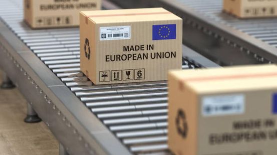 Cartons portant la mention « Made in European Union » et du drapeau de l’UE sur un convoyeur à rouleaux