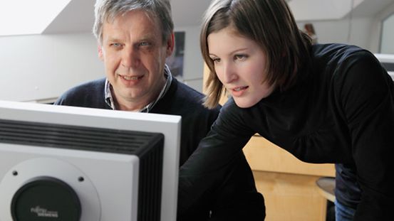 Mann und Frau schauen auf einen Computerbildschirm
